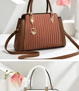 Detalle de bolso de mano plisado con herrajes dorados y un colgante de bailarina