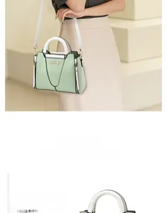 Detail view of the green and white contrast handbag featuring a gold logo and metal zipper