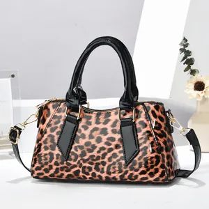 Modische Handtasche mit Leopardenmuster, schwarzen Lacklederbesätzen und Goldbeschlägen