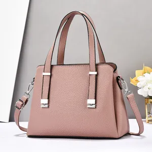 Détail d'un sac à main en cuir grainé rose avec ferrures argentées et bandoulière amovible