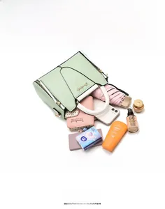 Practical capacity view of light green tote bag showing storage of phone and umbrella