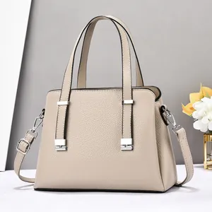 Sac à main chic en cuir beige avec double poignée et détails métalliques argentés