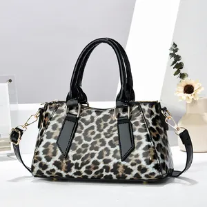 Details der Handtasche mit Leopardenmuster, glänzender Textur und Goldbeschlägen