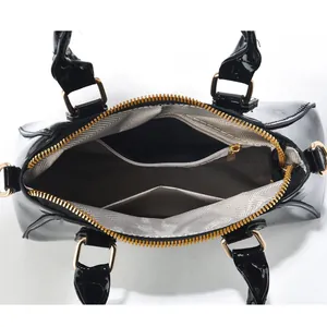 Draufsicht auf das Innenfutter der schwarzen Lackledertasche mit grauen Innentaschen