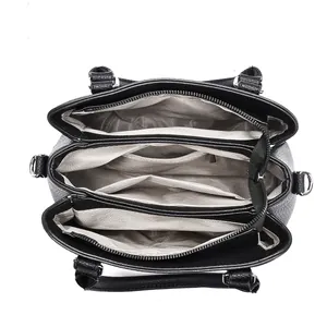 Détail de l'intérieur du sac en cuir noir avec trois compartiments et doublure grise