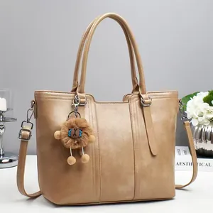 Khaki leather bucket bag with plush toy pendant and adjustable shoulder strap for women