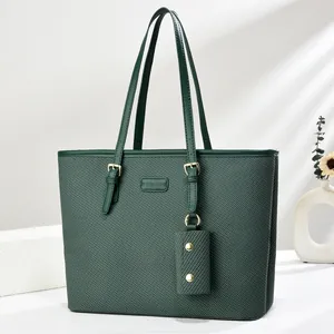 Detail of dark green woven tote bag with a small matching purse and gold hardware