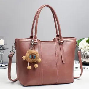 Dusty pink multi-functional bucket tote bag with adjustable strap and plush charm