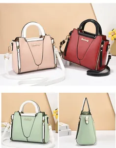 Detailed view of fashionable contrast-color handbags with metallic logo and textured leather