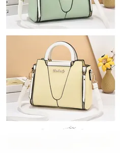 Detail showing contrast color design with white handle and metal logo on beige handbag