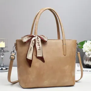 Chic light brown PU tote bag with a decorative silk scarf and adjustable shoulder strap
