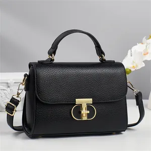 Sac à bandoulière chic en cuir noir avec fermoir en T doré et détail floral élégant