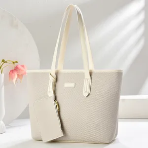 Large beige woven tote bag with matching pouch and stylish leather trim details