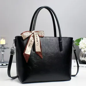 Fashionable black PU leather tote bag with elegant silk scarf and adjustable shoulder strap