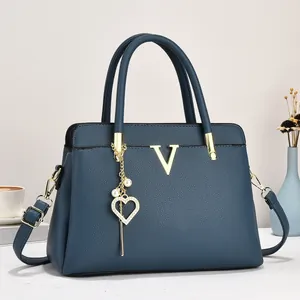 Détail du sac cabas bleu marine avec logo V doré et breloque en perles raffinée