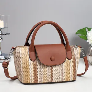 Dettaglio della trama in paglia intrecciata e finiture in ecopelle marrone della borsa