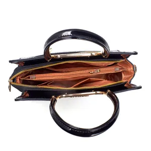 Vue de l'intérieur du sac en cuir verni avec doublure orange et poignée en métal doré