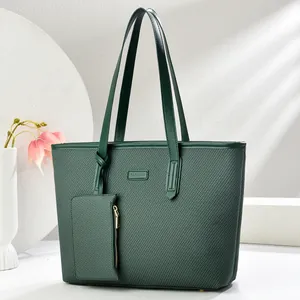 Detail of dark green tote bag featuring textured fabric and a matching small zipper pouch