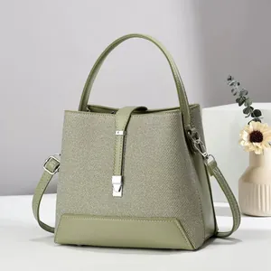 Minimalist olive green bucket bag in textured canvas and smooth leather patchwork