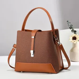 Close-up of brown bucket bag showing woven texture and smooth leather patchwork