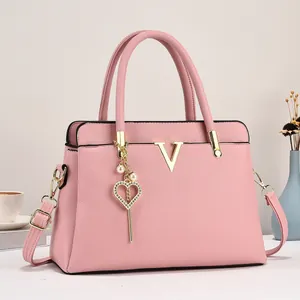 Sac cabas rose en cuir grainé avec motif V doré et pendentif cœur en perles