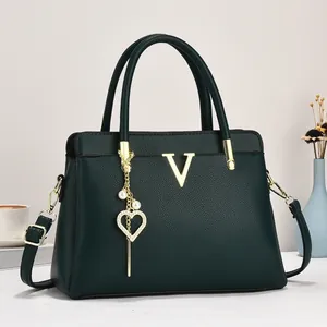 Détail du cabas en cuir grainé vert foncé avec logo V doré et breloque en perles