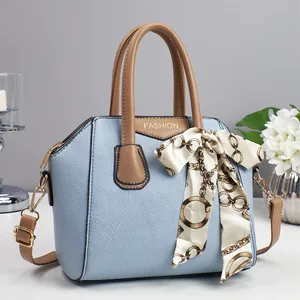 Hellblaue Hobo-Tasche aus Kunstleder mit braunen Griffen und elegantem Seidenschal-Dekor