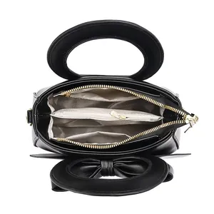 Vue intérieure du sac à main noir à nœud montrant les trois compartiments et la doublure