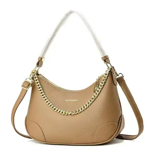 Détail du cuir à motif litchi et de la chaîne dorée sur le sac croissant marron