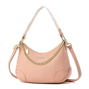 Sac croissant en cuir rose avec chaîne dorée et poignée supérieure sur fond blanc pur