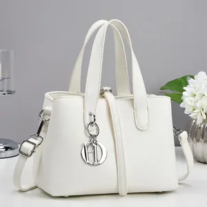 Elegant white faux leather crossbody handbag with minimalist HD metal pendant and slim handles