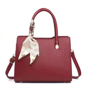 Elegant burgundy leather top-handle bag with striped scarf detail and shoulder strap