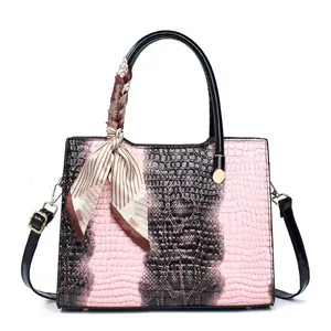 Detail of pink crocodile pattern tote with silk scarf handle and gold hardware
