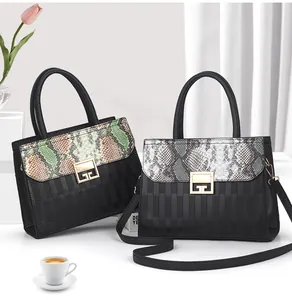 Dettaglio borsa a mano in pelle motivo serpente con chiusura dorata geometrica