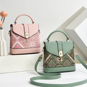 Retro pixel-style printed shoulder bag with geometric patterns and bear-shaped lock