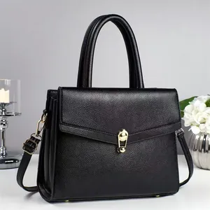 Solid black litchi pattern leather handbag with gold cat-shaped buckle and crossbody strap