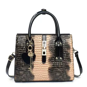 Sac à main chic à motif crocodile beige et marron avec poignées rondes et pendentif en cœur