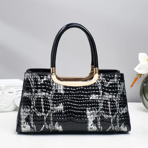 Détails du sac à main brillant motif crocodile avec ferrures dorées et poignée supérieure