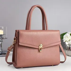 Minimalist dusty rose leather shoulder bag with gold rotary lock and top handle