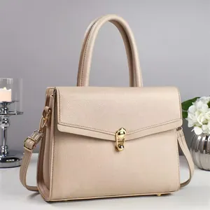 Beige pebble leather handbag with gold rotary lock shown from a professional studio angle