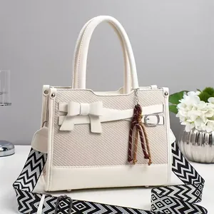 Borsa a mano bianco crema in pelle intrecciata con fiocco e tracolla geometrica