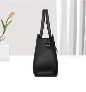 Vista laterale della borsa shopping nera con struttura trapezoidale e fibbia a D