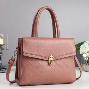 Elegant dusty rose crossbody bag with diamond quilting and gold twist lock in soft lighting