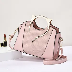 Borsa a conchiglia rosa con manici dorati a orecchie di gatto e dettagli intrecciati