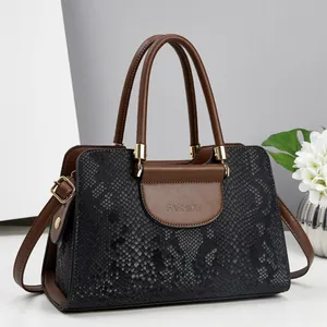 Detail of black snake pattern leather bag with brown trim and gold-tone fashion logo