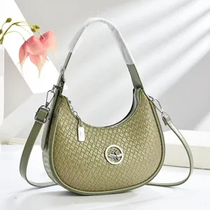 Sac croissant tressé vert avocat avec boucles argentées et bandoulière réglable chic