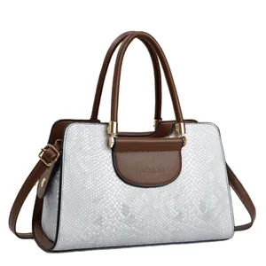 Minimalist white snakeskin pattern handbag with brown leather handles and gold metal hardware