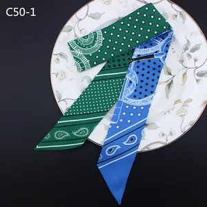 Detail von Twilly-Schals mit Paisley- und Sternmuster in Grün und Blau auf Tablett