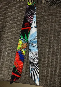 Detalle de un pañuelo de seda estrecho con motivos de plumas y extremos de corte diagonal
