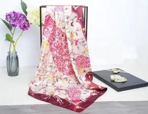 Details von elegantem Seidenschal mit Blumenmuster und rotem Rand am Ständer